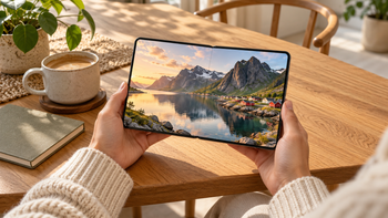 Een opengevouwen smartphone in gebruik aan een houten tafel